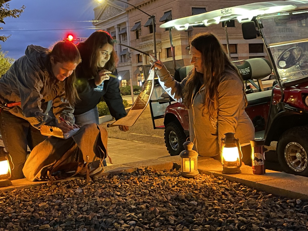 women looking at clue via lantern light prescott az