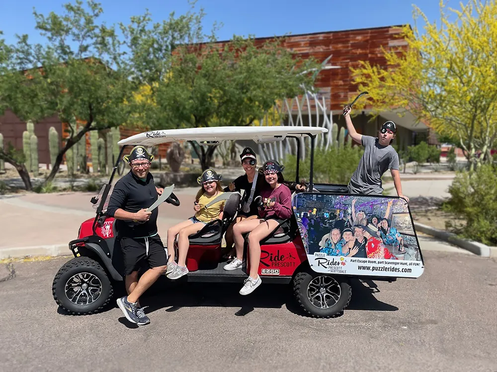 Family in pirate costumes on Puzzle Rides golf cart during Pirate’s Treasure Adventure in Scottsdale