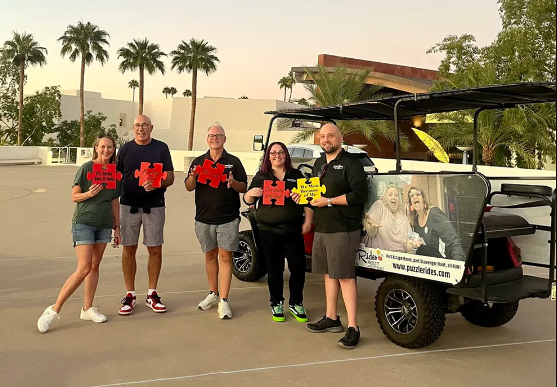 group of male and female coworkers enjoying team building golf cart fun